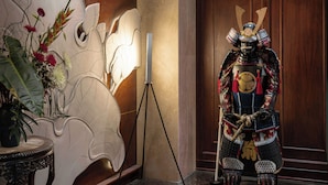 A traditional Japanese warrior statue in a lobby with a sign for 'The Odyssey Boutique Hotel'.