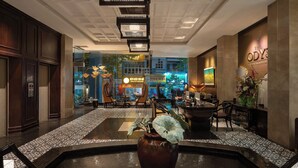 A lobby with a reception desk, seating area, and a decorative fountain.
