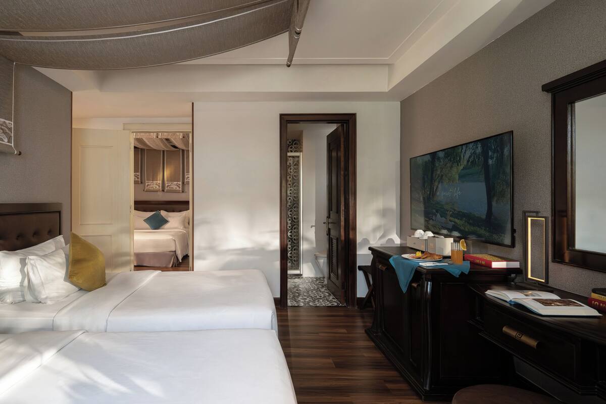 Une chambre d’hôtel avec un grand lit, un bureau avec un ordinateur et une grande fenêtre.