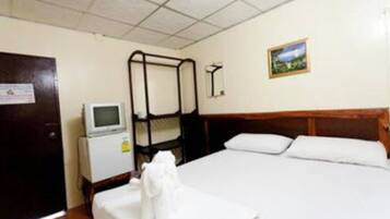 A hotel room with a bunk bed, a small desk with a computer, a television, and a framed picture on the wall.