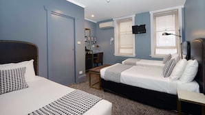 A bedroom with two beds, a desk, and a TV. - The Maisonette (Potts Point)