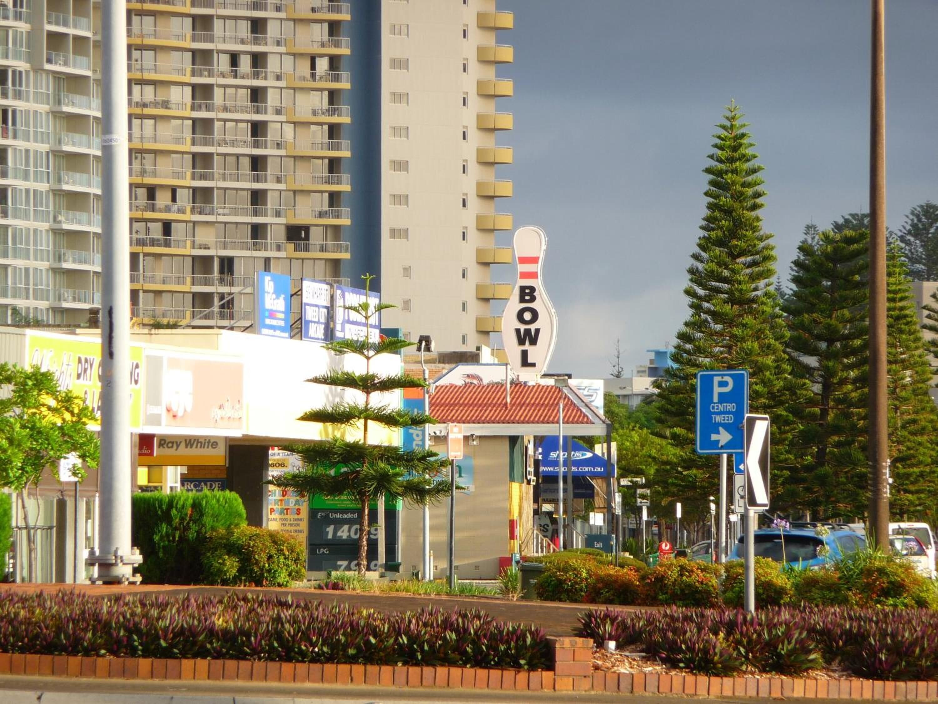 A multi-story building with a sign that reads "BOWL" and a parking sign indicating a parking area.