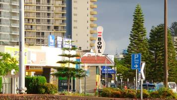 A multi-story building with a sign that reads "BOWL" and a parking sign indicating a parking area.