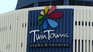 A building with a sign that reads "Twin Towns clubs & resorts" and a colorful logo above the text. - Blue Pelican Motel (Tweed Heads)