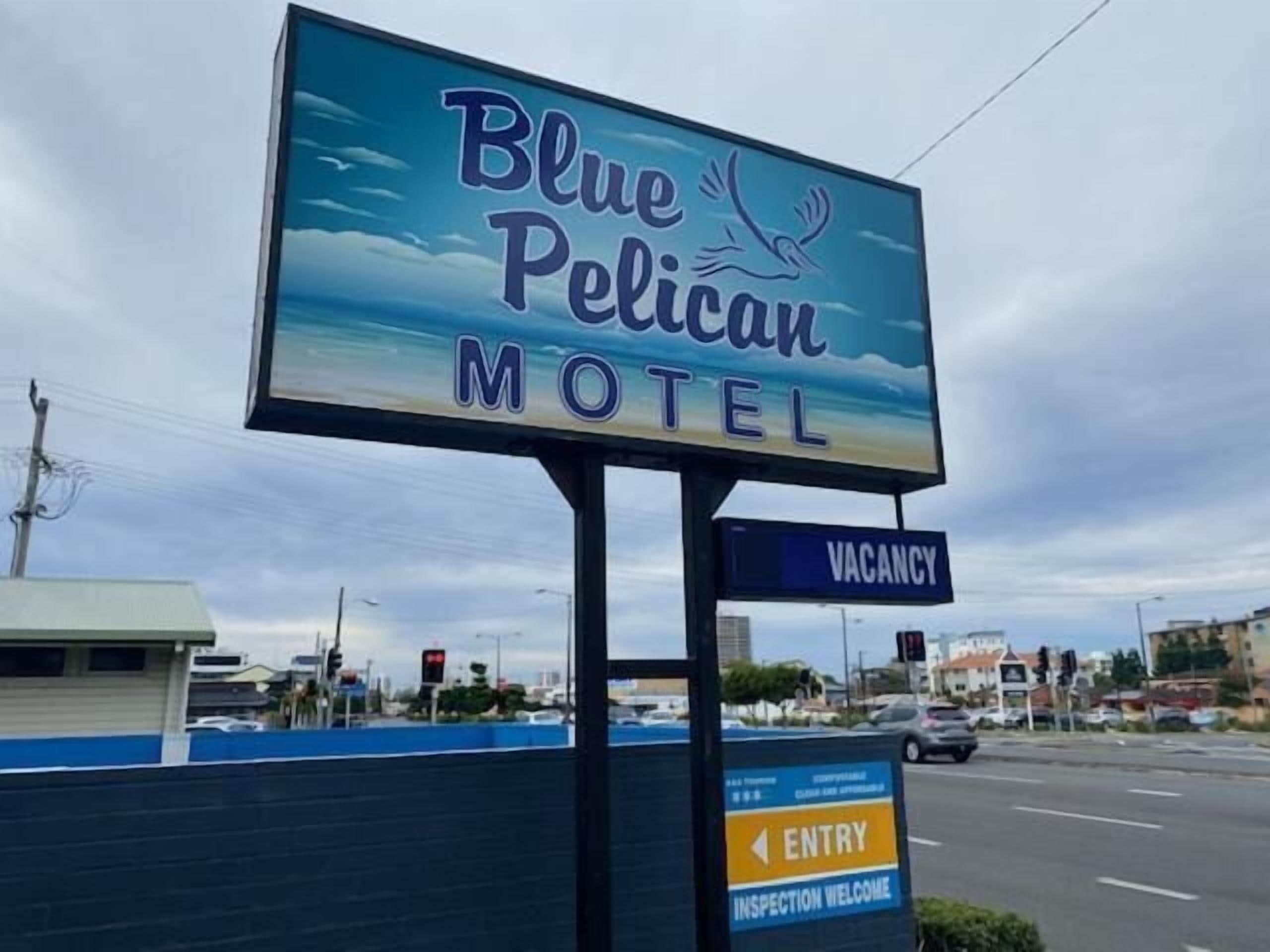Een motelbord met een vogel en de naam 'Blue Pelican Motel'.