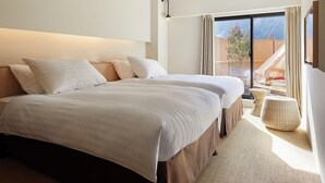 Une chambre d’hôtel moderne avec un grand lit, une petite table et une vue sur l’extérieur.