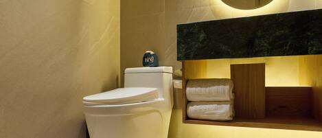 Une salle de bain moderne avec des toilettes blanches, un meuble-lavabo en bois et un plan de toilette en marbre.