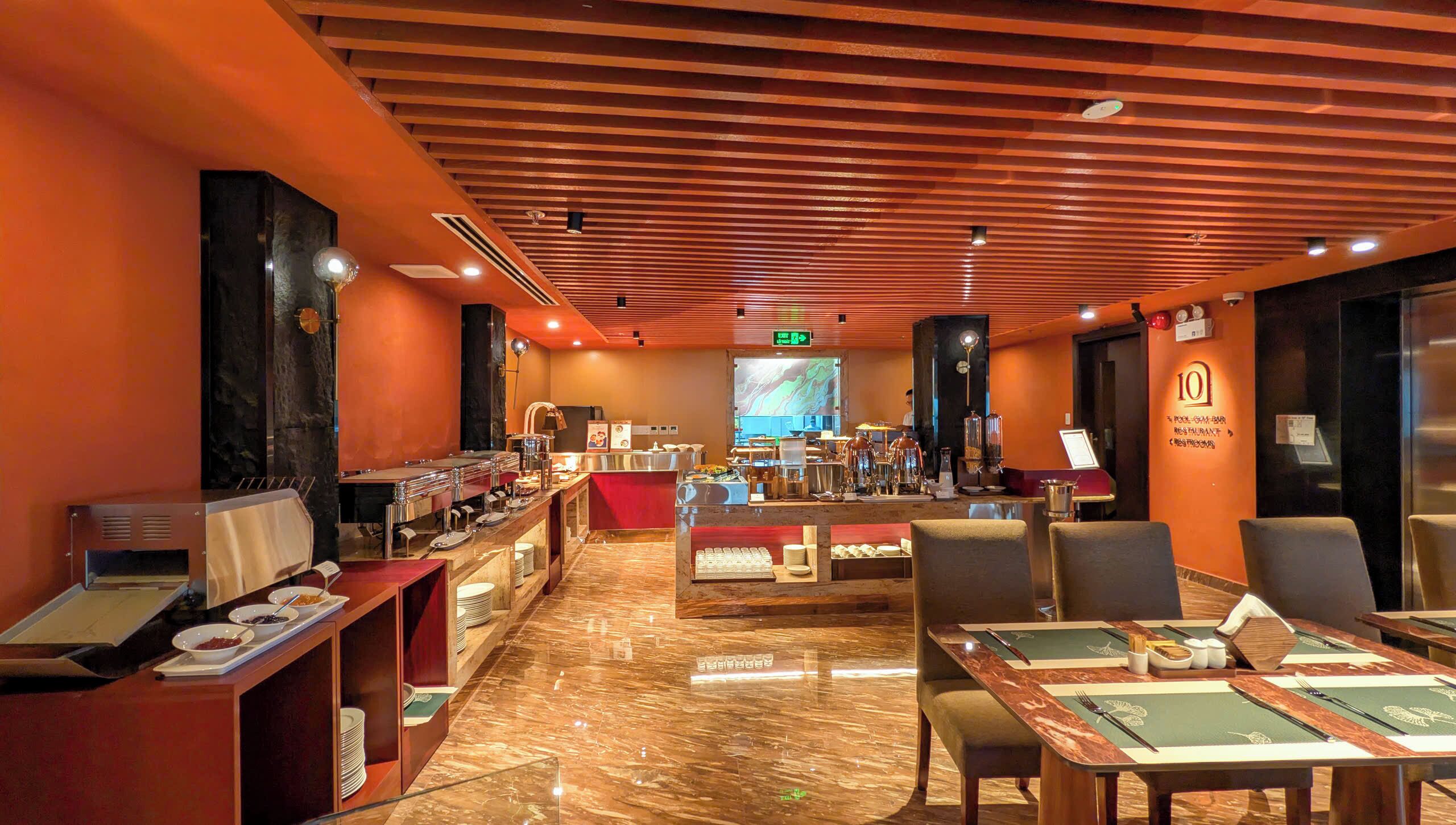 A buffet area with a marble floor, buffet counters, and seating arrangements.