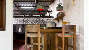 Une cuisine rustique avec un comptoir en bois, des luminaires suspendus et un élément décoratif mural.