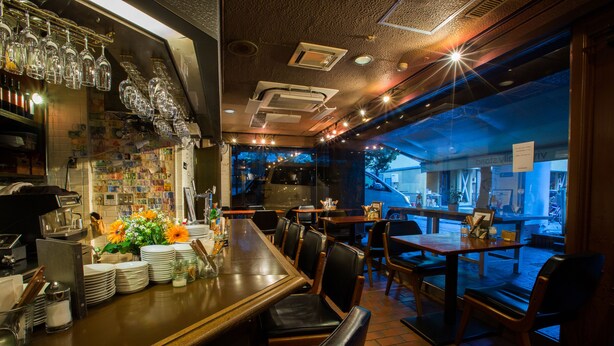 A restaurant with a bar area, tables, chairs, and a view of the street outside. - Hotel Empire in Shinjuku (Tokyo)