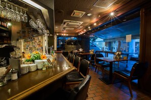 Een restaurant met een bar, tafels, stoelen en uitzicht op de straat.