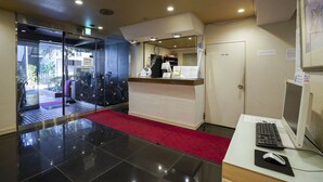 A reception area with a desk, computer, and a red carpet leading to the entrance. - Hotel Empire in Shinjuku (Tokyo)