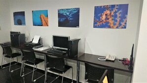A conference room with four computer stations, a telephone, and three framed pictures on the wall. - Smile Hotel Okinawa Naha (Naha)