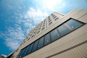 Un edificio moderno con una facciata piastrellata e una griglia di finestre.