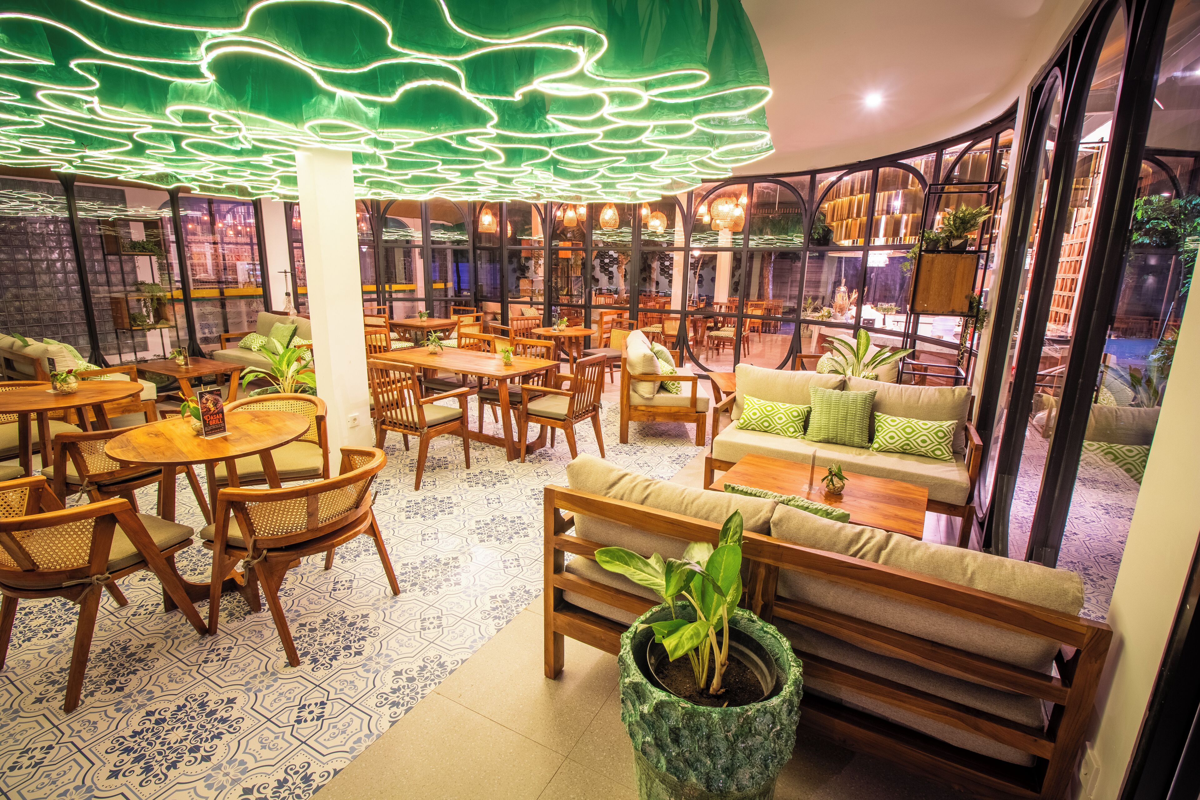 A cozy restaurant with wooden furniture, green plants, and a unique ceiling design.