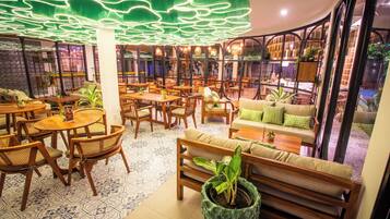 Un restaurante acogedor con muebles de madera, plantas verdes y un diseño de techo original.