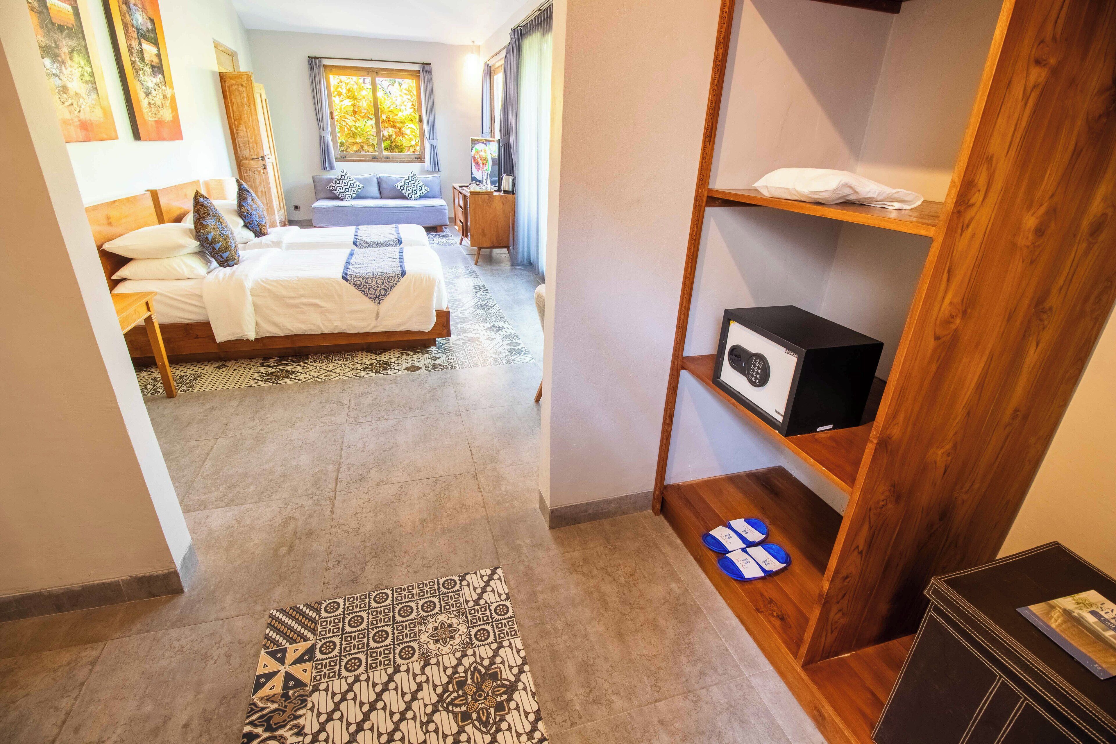 Een slaapkamer met een bed, een bureau, een stoel, een plank met een magnetron, en een kamerkleed met een patroon.