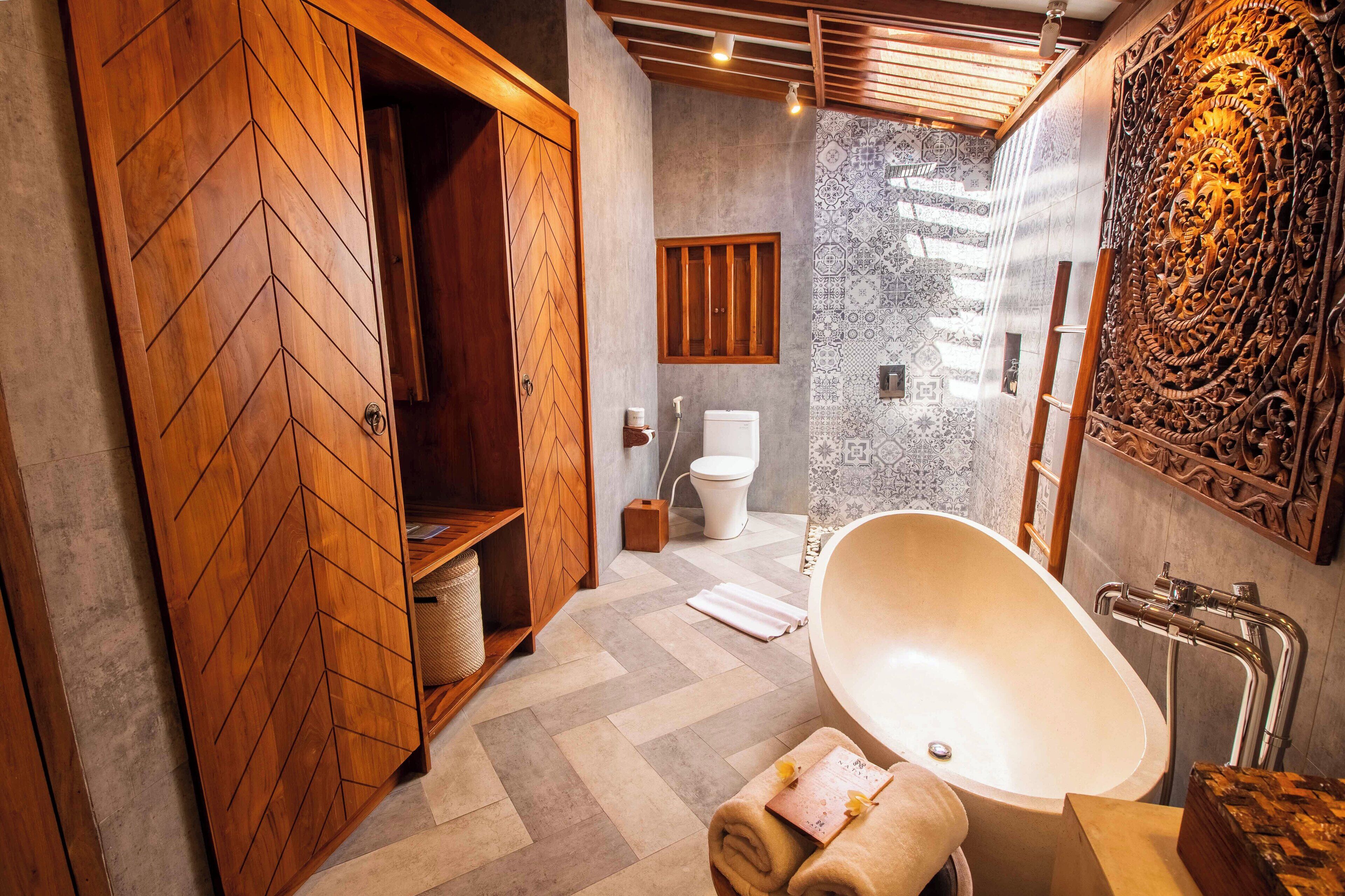 Een moderne badkamer met een vrijstaand bad, een houten kledingkast en een douchehoek.
