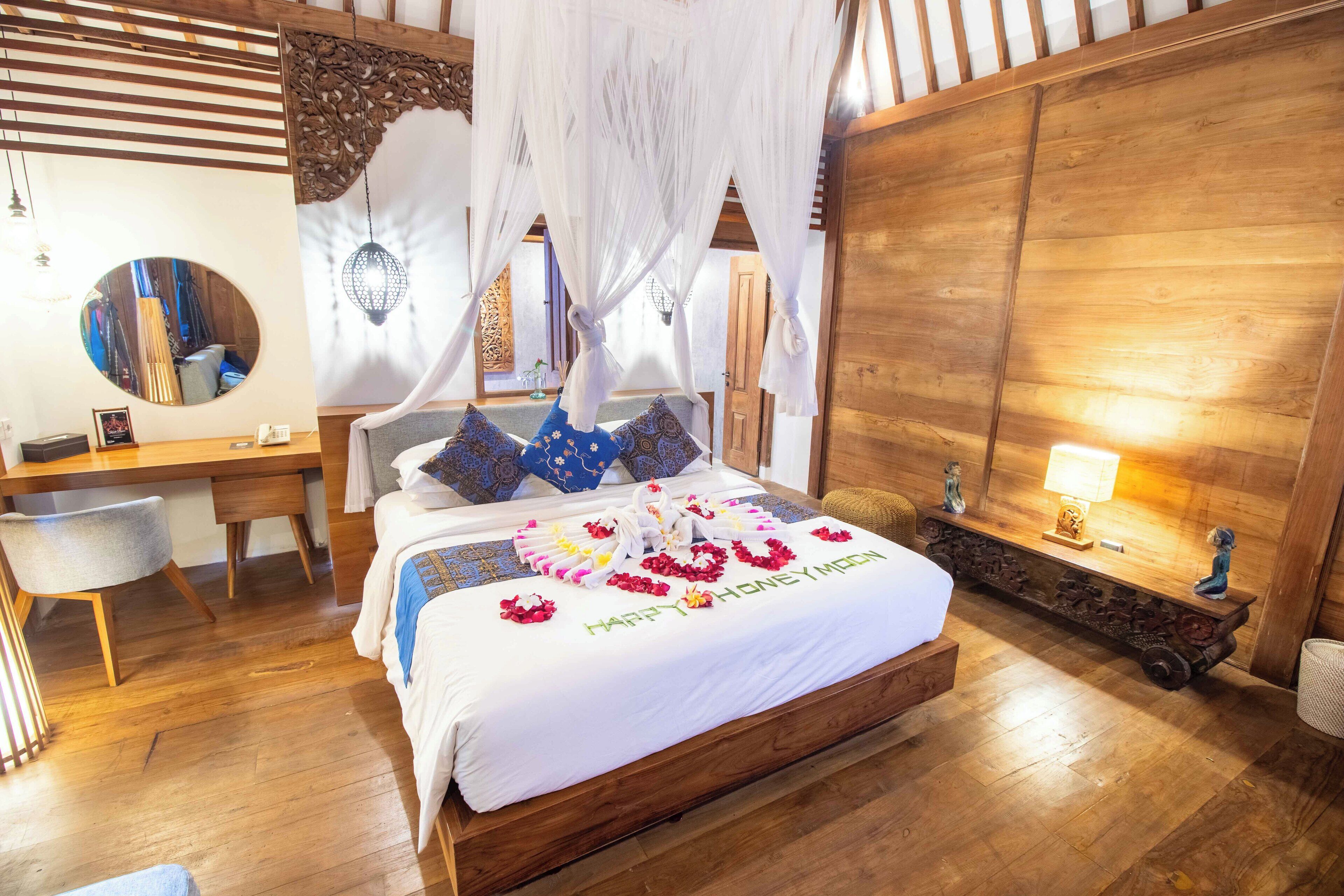 A well-appointed bedroom with a wooden bed, a desk, a chair, and a large mirror.