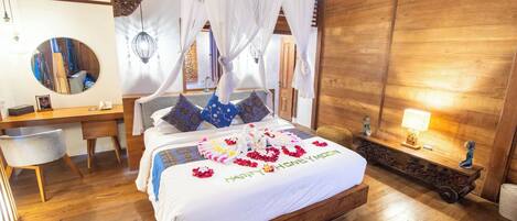 A well-appointed bedroom with a wooden bed, a desk, a chair, and a large mirror.