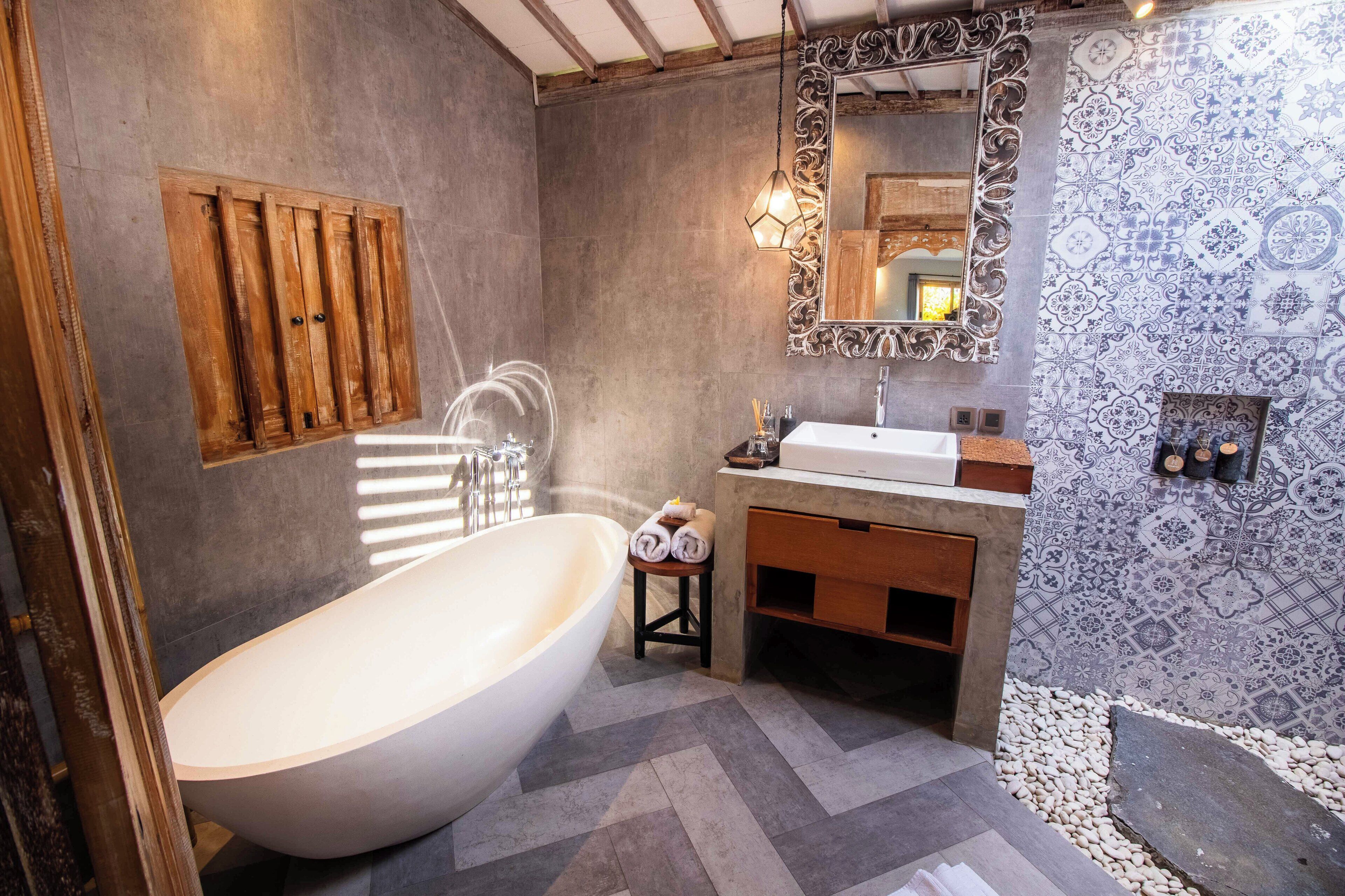 Ein modernes Badezimmer mit freistehender Badewanne, einem Holzbadezimmer-Möbel und einem dekorativen Spiegel.