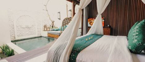 Un dormitorio con cama, dosel, vista a una piscina exterior y pared de piedra.