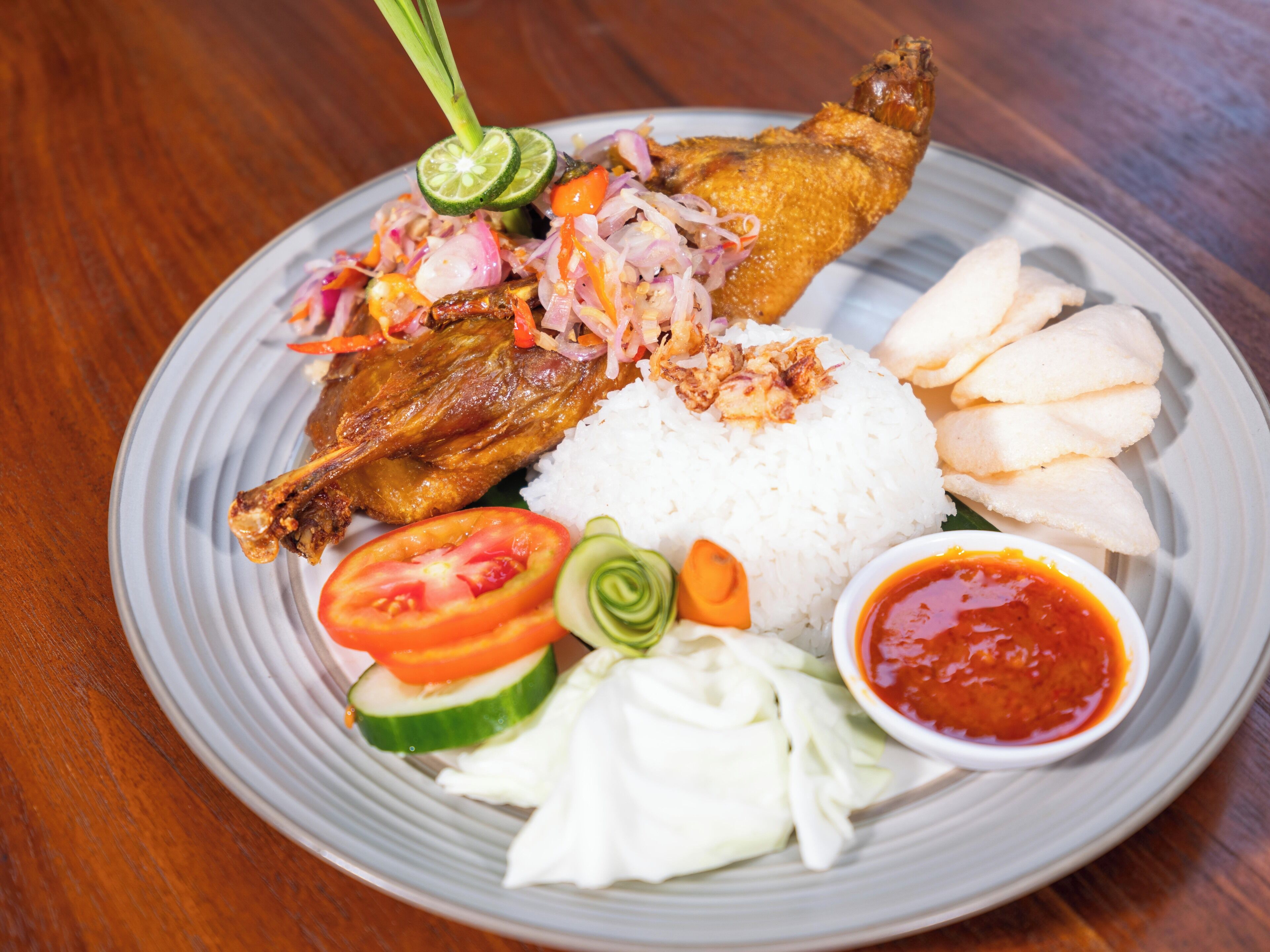 A plate with fried fish, rice, and vegetables.