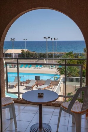 A balcony with a view of a pool and the sea. - Hotel Orizonte (Cervione)