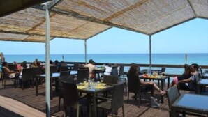 An outdoor dining area with tables and chairs, overlooking the sea. - Hotel Orizonte (Cervione)