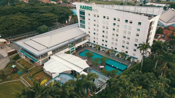 Un hôtel Harris doté d’une grande piscine, d’un patio couvert et d’une végétation luxuriante.