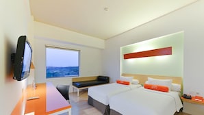 Une chambre d’hôtel moderne équipée de deux lits, d’un bureau, d’une télévision et d’une grande fenêtre.