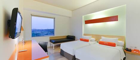 Una habitación de hotel moderna con dos camas, un escritorio, un televisor y un ventanal grande.