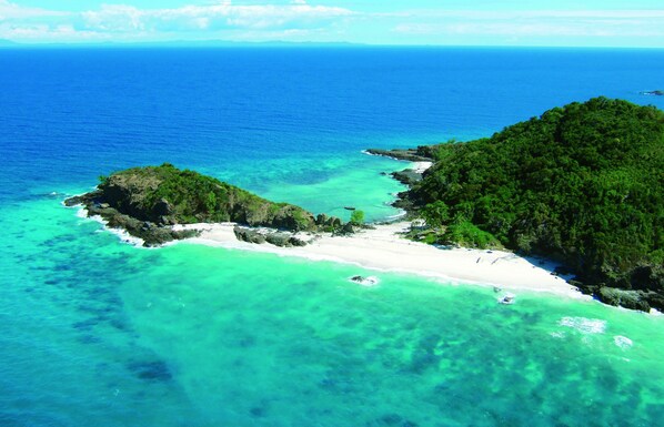 An aerial view of a tropical island with clear turquoise waters, white sandy beaches, and lush green vegetation. - Constance Tsarabanjina (Tsarabanjina)