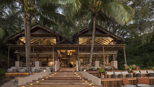 A wooden building with a staircase leading to a covered area with seating. - Constance Tsarabanjina (Tsarabanjina)