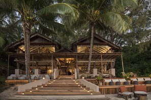 A wooden building with a staircase leading to a covered area with seating. - Constance Tsarabanjina (Tsarabanjina)