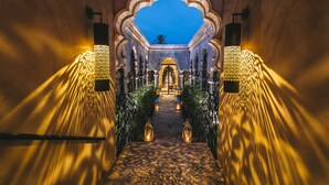 A corridor with ornate arches and lanterns, leading to a central doorway. - Palais Namaskar (Marrakech)