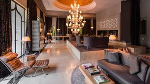 A spacious lobby with a grand chandelier, comfortable seating, and a modern fireplace. - Palais Namaskar (Marrakech)