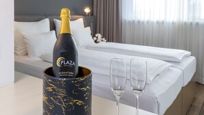 A minibar with a bottle of champagne and two glasses on a hotel room table. - PLAZA INN Graz Messe (Graz)
