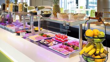 Un buffet proposant divers plats et un panier de fruits.