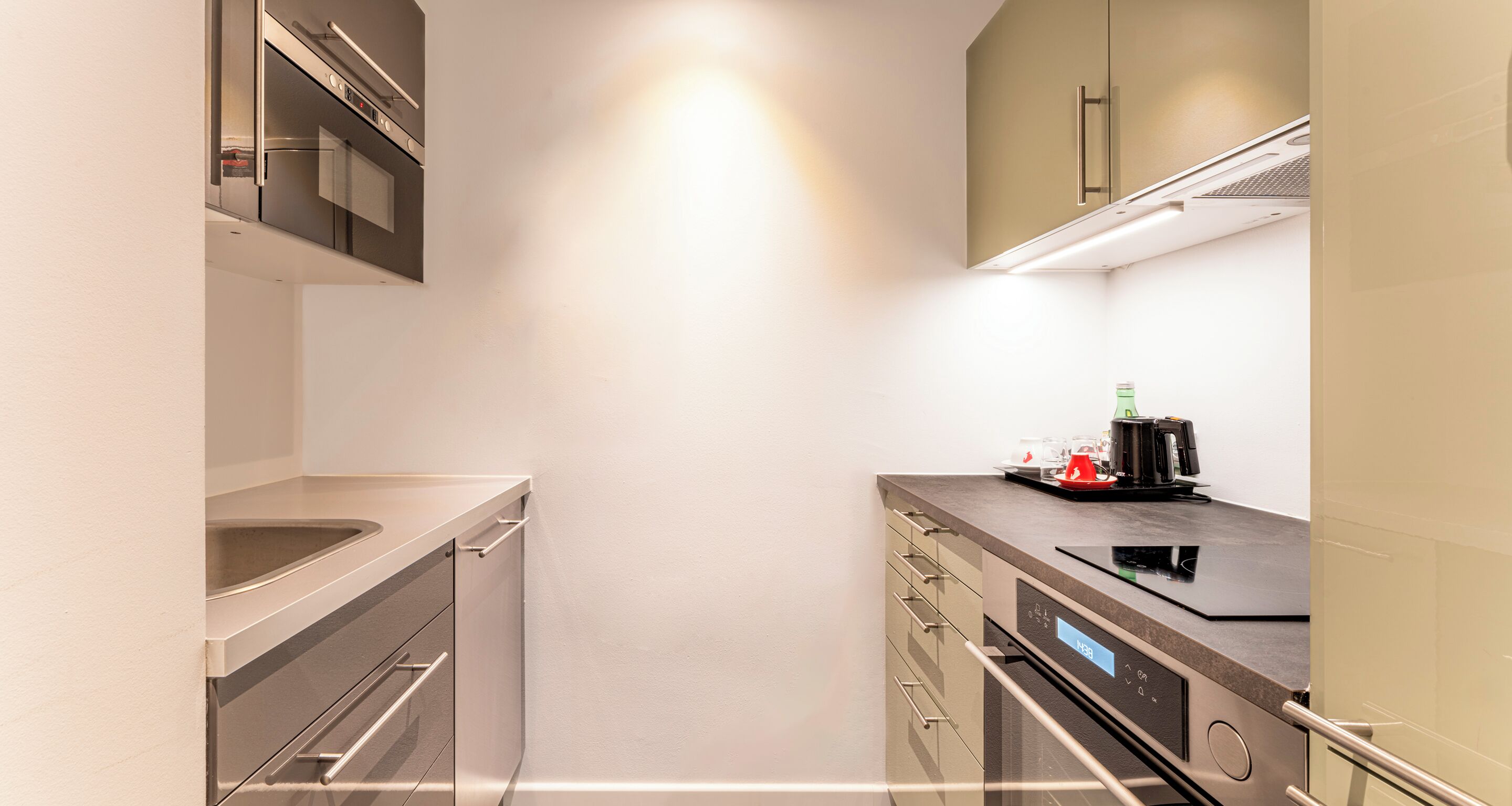 A modern kitchen with stainless steel appliances, a built-in oven, and a coffee maker on the counter.