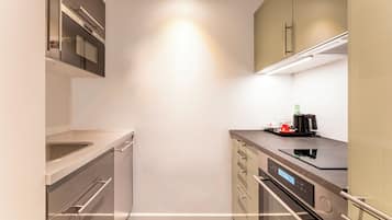 A modern kitchen with stainless steel appliances, a built-in oven, and a coffee maker on the counter.