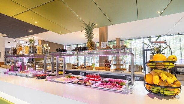 A buffet with various food items and a decorative pineapple centerpiece. - PLAZA INN Graz Messe (Graz)