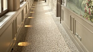 A long corridor with arched ceilings and large windows, featuring wall-mounted sconces and a mural of a landscape. - Palazzo Righini (Fossano)