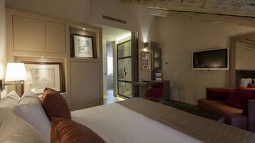 A hotel room with a large bed, a desk with a chair, a TV, and a mirror.