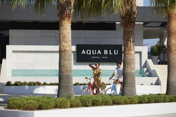 A modern building with a sign reading "AQUA BLU HOTEL SPA".