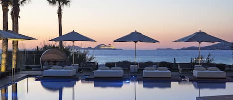 Piscine extérieure, parasols de plage, chaises longues