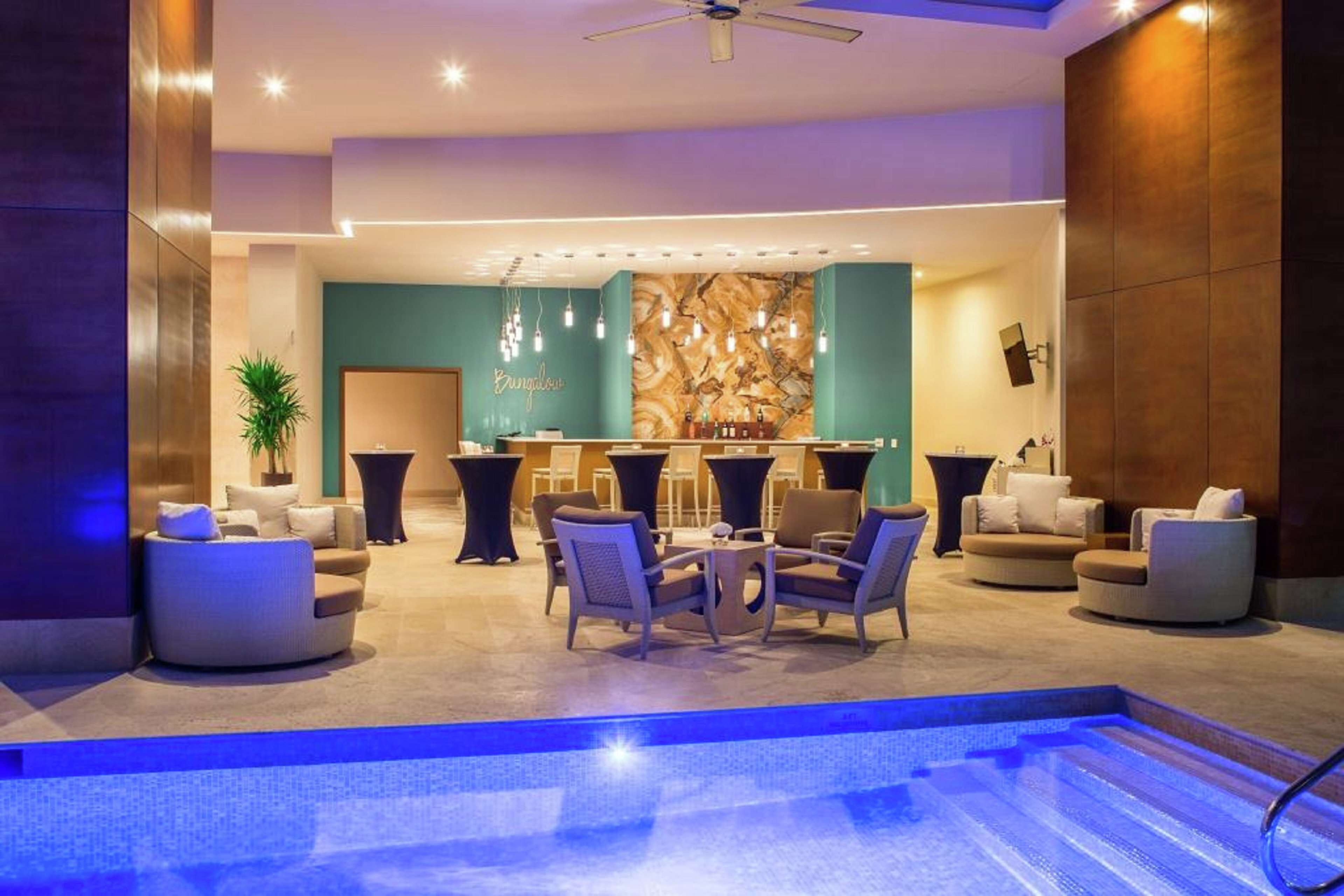 Una piscina al aire libre, sombrillas, sillones reclinables de piscina