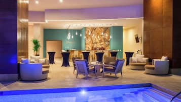 Una piscina al aire libre, sombrillas, sillones reclinables de piscina