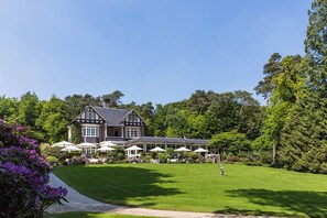A large, traditional house with a well-maintained lawn and outdoor seating area. - Landgoed Hotel Het Roode Koper (Ermelo)