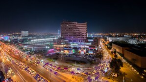 A multi-story building with a prominent 'STADIUM' sign, surrounded by busy roads and other commercial buildings. - Hotel Plaza Stadium (León)